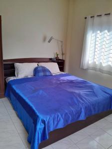 a bedroom with a blue bed with a blue blanket at Thongkham house in Ban Chek
