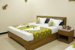 a bedroom with a large bed with white sheets at Hotel New Amirtham inn in Palni +31 photos
