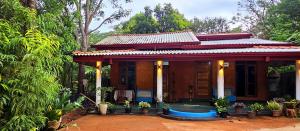 a house with a porch with a pool in front at Dilanya Homestay in Habarana