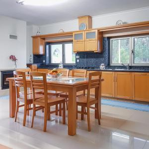 a kitchen with a wooden table and chairs at Villa Royal Natura - Private Villa in Pombal in Pombal