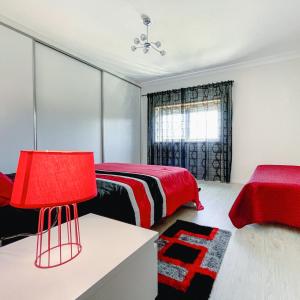 a bedroom with a bed and a red lamp at Villa Royal Natura - Private Villa in Pombal in Pombal +4 photos