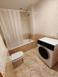 a bathroom with a toilet and a washing machine at Seawolf Apartment, Lloret de Mar in Lloret de Mar