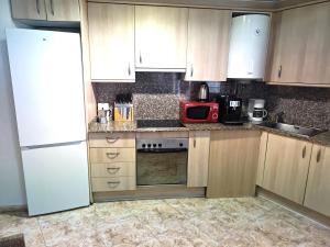 a kitchen with wooden cabinets and a white refrigerator at Seawolf Apartment, Lloret de Mar in Lloret de Mar +7 photos
