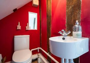 czerwona łazienka z umywalką i toaletą w obiekcie Hylton Cottage, Lavenham w mieście Lavenham +12 zdjęć