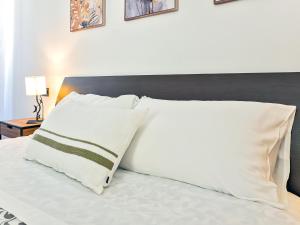 a bed with white pillows and a black headboard at Center House Via Anghileri in Lecco