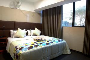 a bedroom with a bed with a teddy bear on it at Hotel Lima City in Lima +2 photos