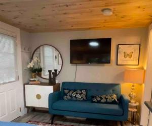 a living room with a blue couch and a mirror at Cheerful Cottage Close to Everything 13 in Edgecomb