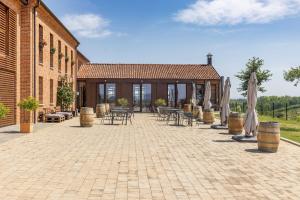 a patio with tables and chairs and umbrellas and a building at Villaggio Brambui Durando in Portacomaro