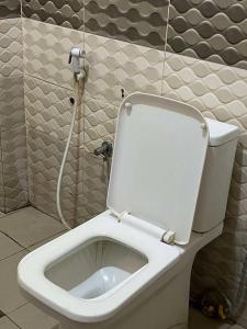 a bathroom with a white toilet with a shower at Orange Room in Dakar