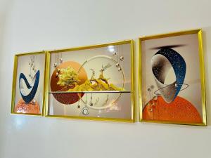 a group of four framed pictures on a wall at Orange Room in Dakar