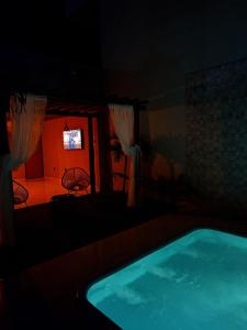 a dark room with a swimming pool and a tv at Villa Oásis Espaço para eventos in Anápolis +1 photo