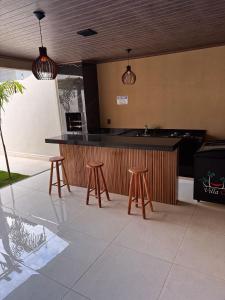 a kitchen with a bar with stools and a counter at Villa Oásis Espaço para eventos in Anápolis