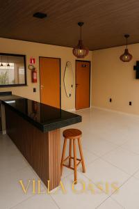 a kitchen with a counter and a stool in a room at Villa Oásis Espaço para eventos in Anápolis
