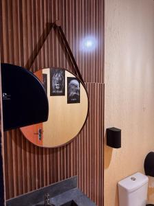 a bathroom with a mirror and a toilet at Villa Oásis Espaço para eventos in Anápolis