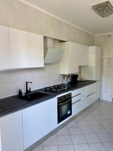 a kitchen with white cabinets and a sink at Appartamento Jaris in Vicenza +13 photos