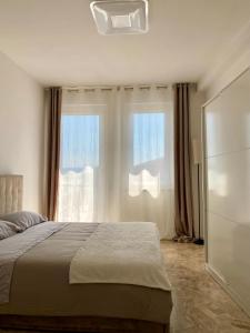 a bedroom with a bed and two large windows at Appartamento Jaris in Vicenza