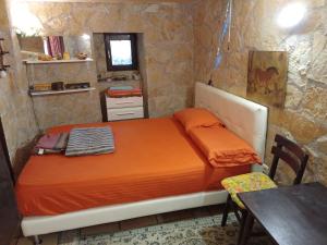 ein Schlafzimmer mit einem Bett mit orangefarbener Bettdecke und einem Tisch in der Unterkunft Menton.Studio in Menton