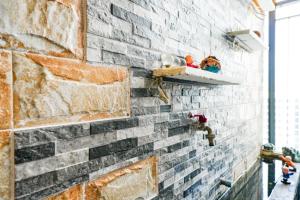 a brick wall with shelves and toys on it at Shi House - Studios S503 Cozy Beautiful Vinhomes in Long Bình