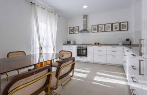 La Perla I في خيريز دي لا فرونتيرا: مطبخ مع خزائن بيضاء وطاولة وكراسي +11 صورة