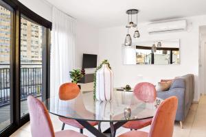 a dining room with a glass table and pink chairs at Deluxe 1 Bedrooms Apartment Terrace in City Center in Jerusalem