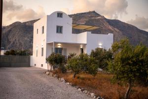 a white house with a mountain in the background at DENIS Summer Living in Perivolos