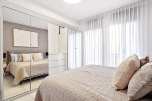 a white bedroom with a bed and a mirror at Deluxe 1 Bedrooms Apartment Terrace in City Center in Jerusalem