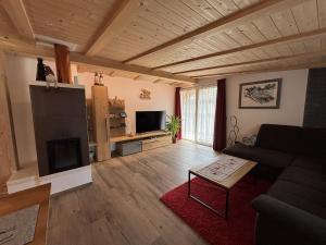 Una sala de estar con un sofá y una chimenea. en Appartamento Cima 12, en Pozza di Fassa