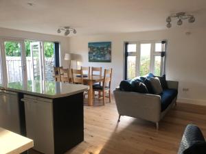 a kitchen and living room with a couch and a table at Caretakers Hideaway in Puncknowle