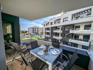 a balcony with a table and chairs and a building at Luxurious new flat with pool & big terrace in Villamartin