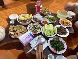 a table with many plates of food on it at Lý Gún homestay in Quang Ba