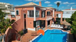 a house with a swimming pool and a house with words home holidays at #307 Vila Branca by Home Holidays in Albufeira +47 photos