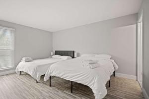two beds in a white room with white walls at Spacious & Stylish Stay in Rochester Prime Spot in Rochester Hills +4 photos