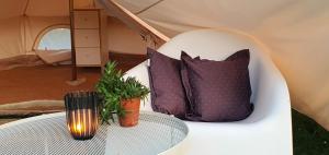a table with pillows and a lamp on a tent at Waldkiez Tiefensee in Tiefensee