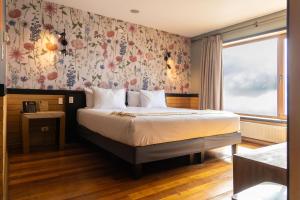 a bedroom with a bed with a floral wallpaper at Hotel Bellavista in Puerto Varas +60 photos
