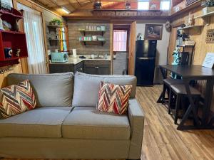 ピジョン・フォージにあるCozy Cabin Walking Distance to Parkway!のソファとテーブルとキッチンのあるリビングルーム +7枚の写真
