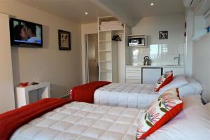 a bedroom with two beds and a tv on the wall at Kokomo Retreat in Russell