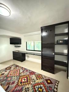 ein Wohnzimmer mit einem Fernseher und einem schwarzen Schrank in der Unterkunft Marazul Hotel Boutique in Isla Mujeres