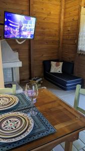 a living room with a table with a wine glass at Penha Chalé frente mar privativo na Praia do Poá in Penha