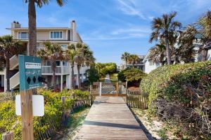 a boardwalk leading to a house with palm trees at 40 Lagoon Villa in Isle of Palms