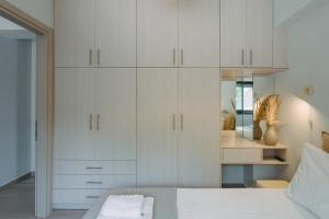 a bedroom with white cabinets and a bed at Amelia Luxury Suite in Nikiana +20 photos