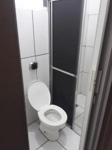 a small bathroom with a toilet and a shower at Salette Hotel in Corumbá