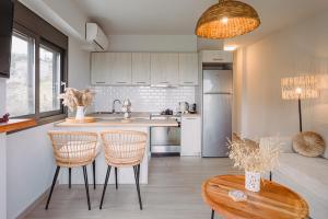 a kitchen with a counter and two chairs and a table at Amelia Luxury Suite in Nikiana