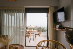 a living room with a sliding glass door with a table at Amelia Luxury Suite in Nikiana