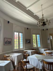 a dining room with tables and chairs and a chandelier at Hotel Vicente López in Vicente López