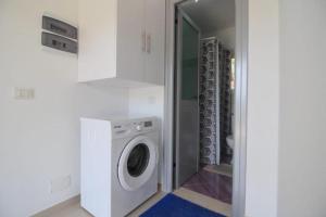 Un lavadero blanco con lavadora y secadora. en Ladin's House, en Sarandë