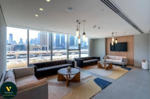 un grand salon avec des canapés et une grande fenêtre dans l'établissement DOWNTOWN VIEWS II - VOGUE One Bedroom Apartment with Balcony, 42nd Floor Opposite Dubai Mall Skybridge, à Sabkhah