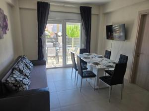 a living room with a table and chairs and a dining room at Stella Apartment in Nikiti