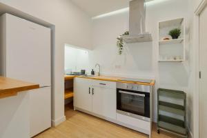 a white kitchen with a sink and a stove at Palmela Oásis Apartment I in Palmela