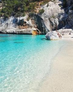 una playa con aguas cristalinas y rocas en Villa Diletta, en Àrbatax