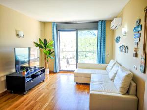 a living room with a couch and a tv at LITORAL COSTA DORADA - Las TERRAZAS 2 in Miami Platja